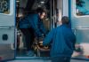 Overdose Deaths Fell for a Third Straight Year. Here Is What the Data Actually Says. Two paramedics loading a stretcher into an ambulance, illustrating emergency overdose response as US overdose deaths decline for a third year