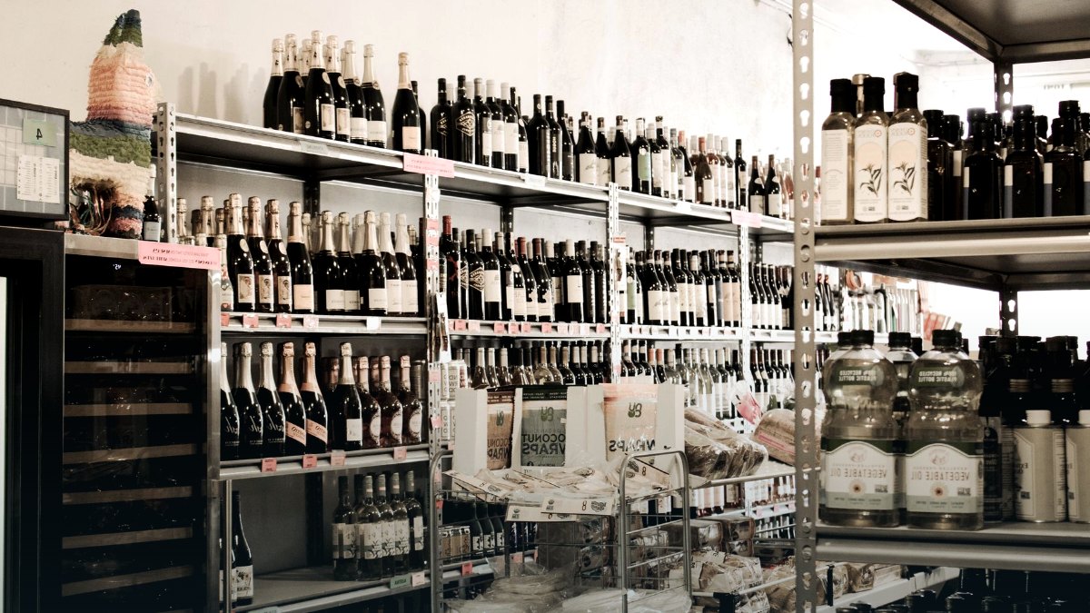 A supermarket aisle lined with wine and spirits bottles.