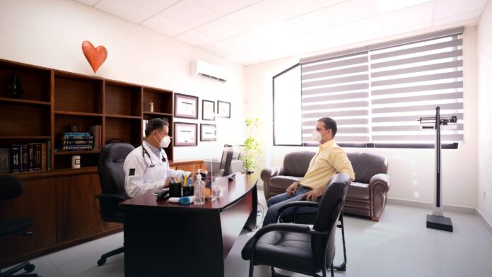 An empty clinical consulting room with a desk and chairs, representing the outpatient settings where contingency management programmes are delivered.