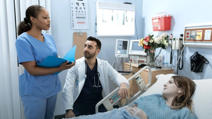 Two doctors and a nurse discussing a patient treatment plan in a clinical setting.
