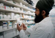 Naloxone Went Over the Counter Three Years Ago. Price and Shelf Placement Still Decide Who Gets It. Shelves of packaged medicines behind a pharmacy counter.
