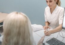 Every State Has a Prescription Monitoring Program. Design Matters More Than Existence. A doctor consulting with a patient at a desk in a modern medical office.