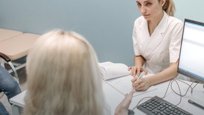A doctor consulting with a patient at a desk in a modern medical office. A doctor consulting with a patient at a desk in a modern medical office.