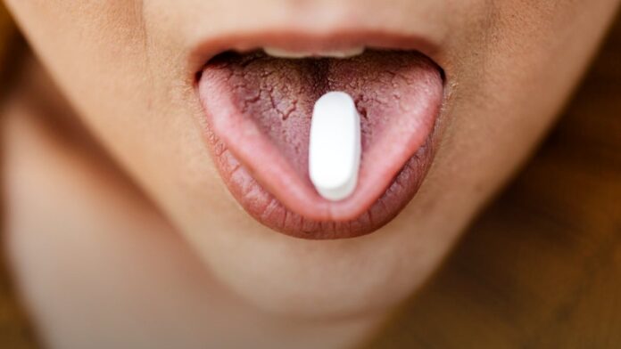 A close view of loose tablets held in an open palm. A close view of loose tablets held in an open palm.