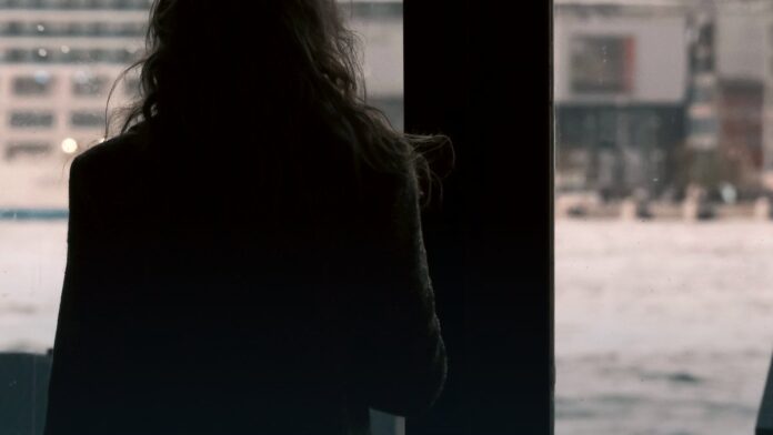 A person lying down resting in a dimly lit room.