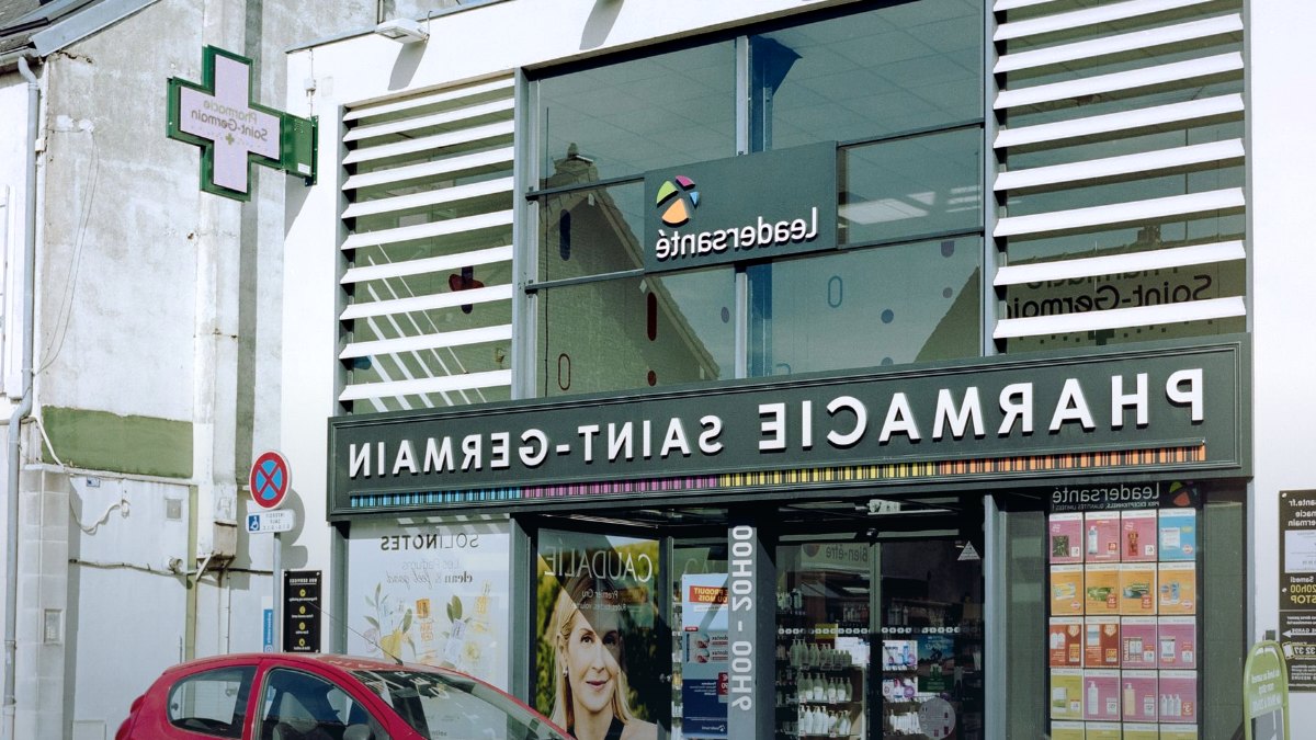 A pharmacy interior with shelves of products behind a counter.