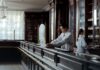 Oxycodone and Hydrocodone: How the Effects and Risks Compare A pharmacist working behind a counter with shelves of medication.